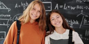 Imagen de dos estudiantes frente a una pizarra