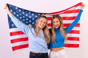 Imagen de dos jovenes con la bandera estadounidense