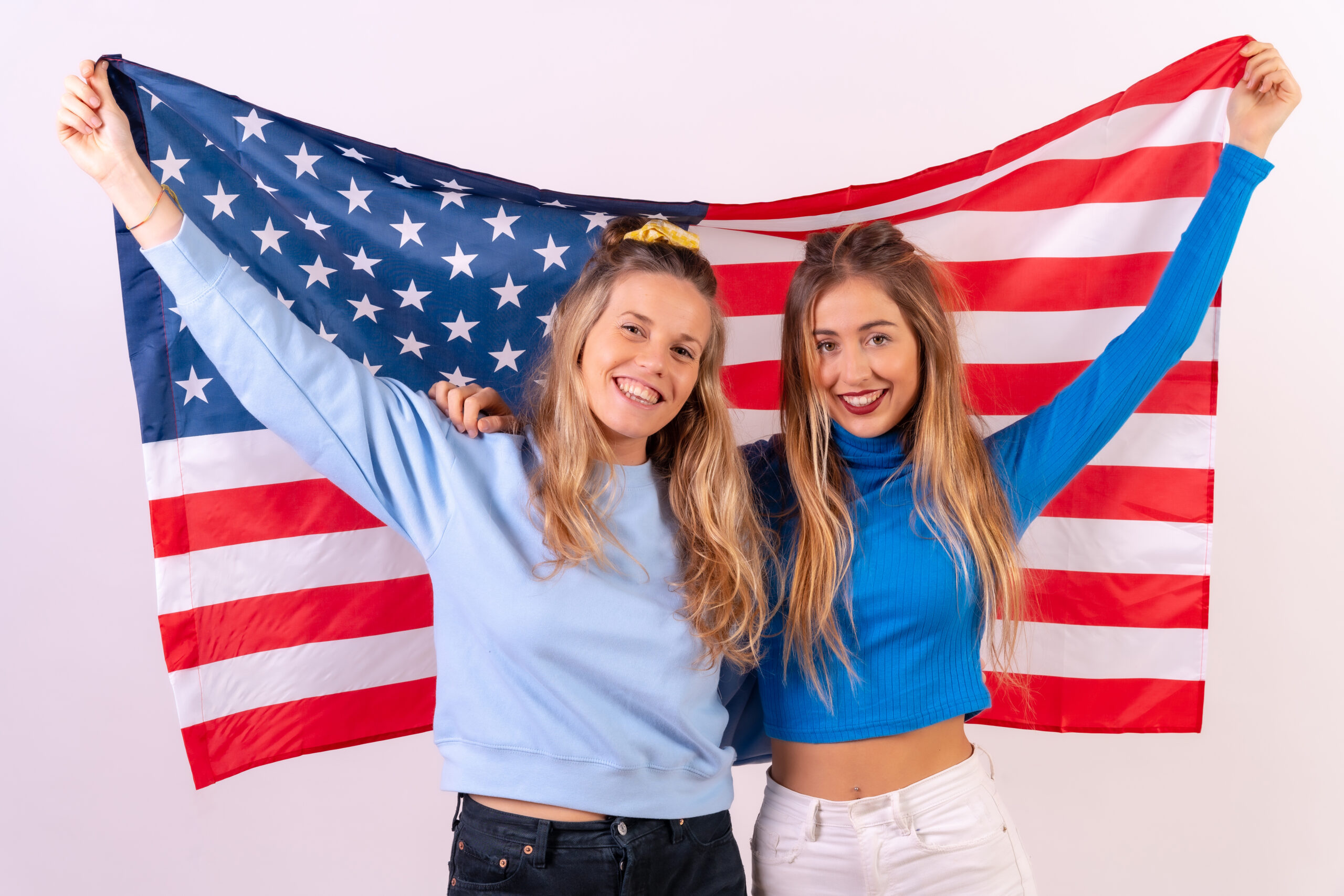 Imagen de dos jovenes con la bandera estadounidense