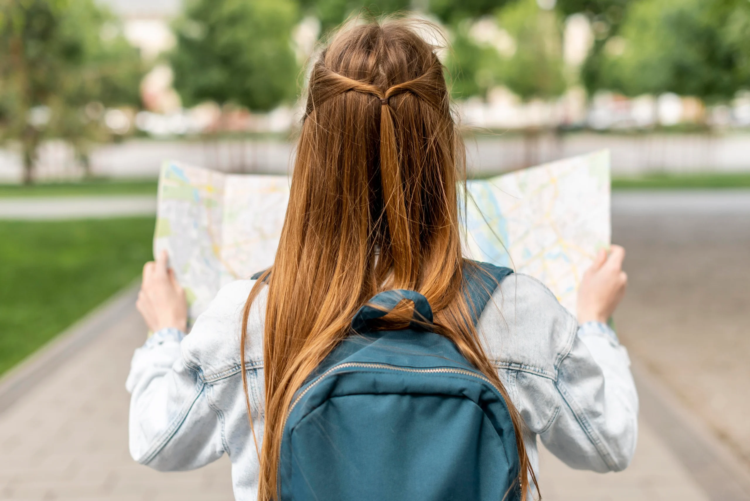 Estudiante adolescente con mochila observando un mapa del campus internacional para estudiar segundo de bachillerato en el extranjero.